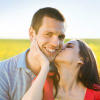 happy-young-couple-in-love-kissing-in-yellow-colza-field