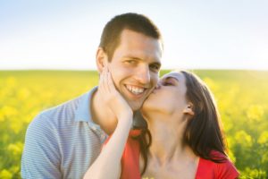 happy-young-couple-in-love-kissing-in-yellow-colza-field