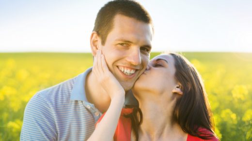 happy-young-couple-in-love-kissing-in-yellow-colza-field